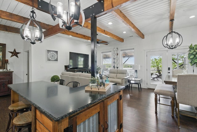kitchen with dark wood finished floors, dark countertops, beam ceiling, and an inviting chandelier
