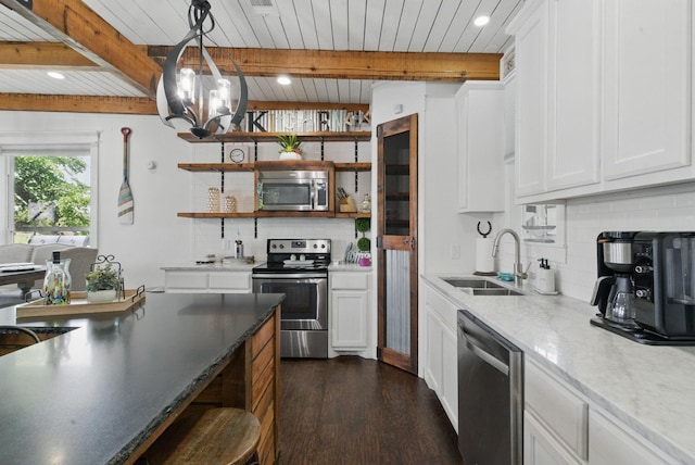 kitchen featuring dark wood finished floors, open shelves, a sink, tasteful backsplash, and appliances with stainless steel finishes