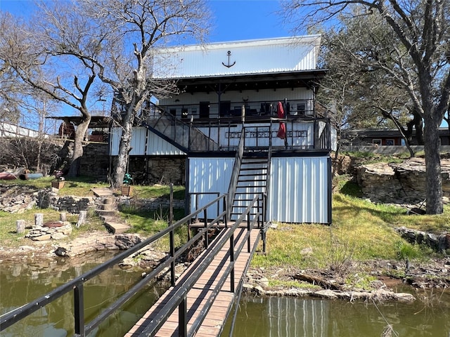 back of house with a water view and stairs