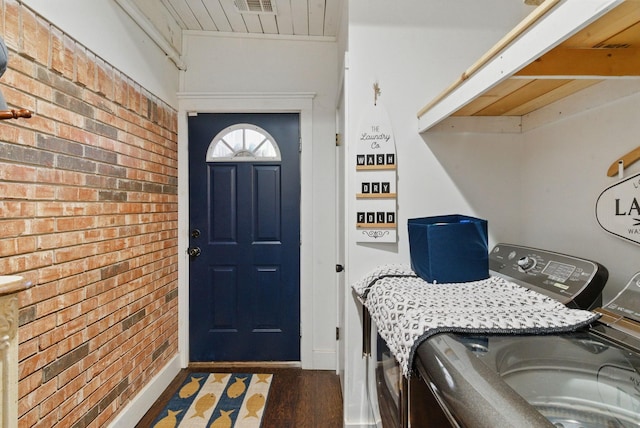 laundry area with laundry area, wood finished floors, independent washer and dryer, wood ceiling, and brick wall