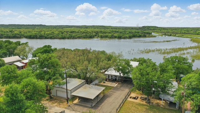 drone / aerial view with a forest view and a water view