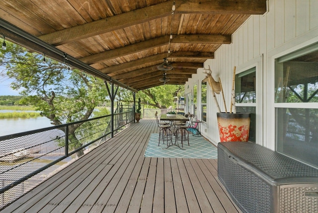 deck featuring outdoor dining space and a water view