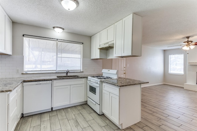 kitchen featuring white appliances, white cabinets, a sink, and under cabinet range hood