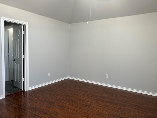 spare room with dark wood-style floors and baseboards