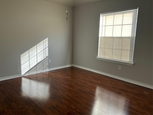 empty room with baseboards and wood finished floors