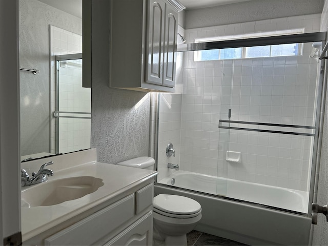 full bath featuring a textured wall, toilet, enclosed tub / shower combo, vanity, and tile patterned flooring