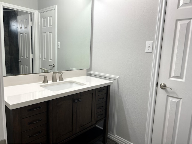 bathroom with a textured wall and vanity