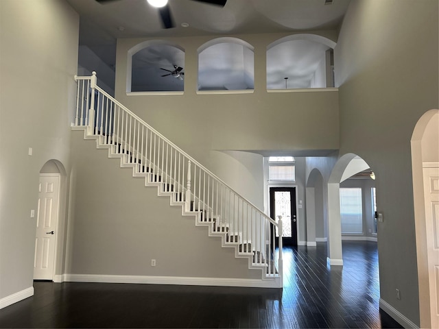 entrance foyer featuring stairs, ceiling fan, baseboards, and wood finished floors