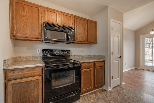 kitchen featuring lofted ceiling, baseboards, brown cabinets, and black appliances