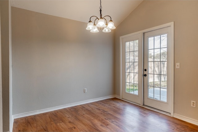 doorway to outside featuring a wealth of natural light, vaulted ceiling, baseboards, and wood finished floors