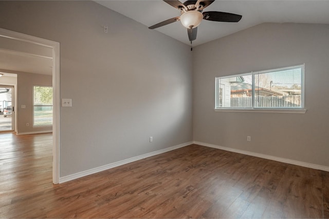 empty room with vaulted ceiling, wood finished floors, a ceiling fan, and baseboards