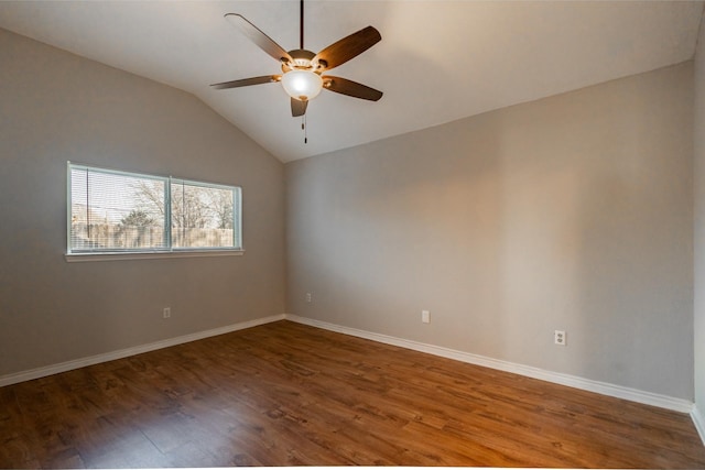 spare room with a ceiling fan, vaulted ceiling, baseboards, and wood finished floors