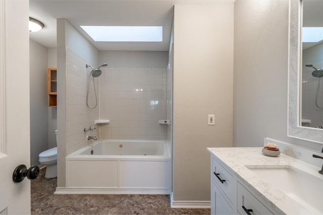 bathroom featuring toilet, a skylight, bathing tub / shower combination, vanity, and baseboards