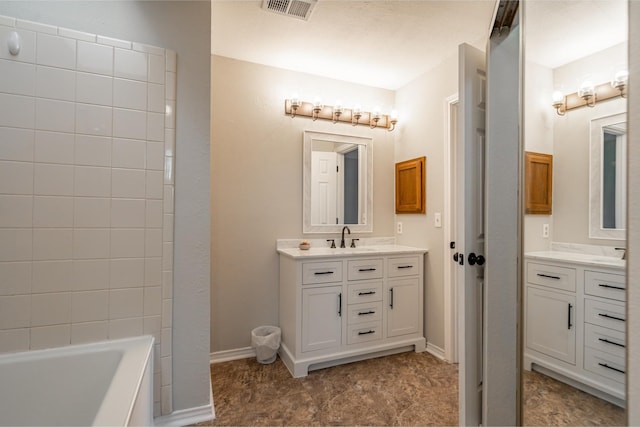 full bath featuring a tub, baseboards, visible vents, and vanity