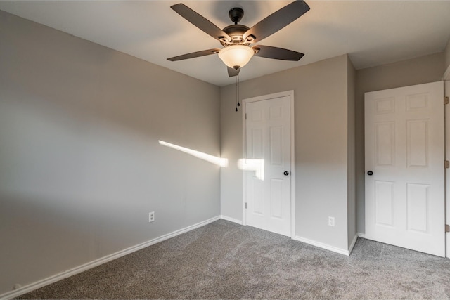 unfurnished bedroom with carpet floors, a ceiling fan, and baseboards