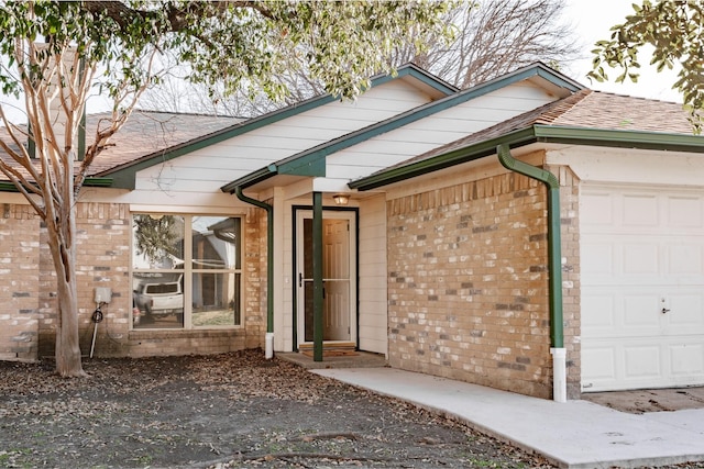 ranch-style house featuring a garage, brick siding, and a shingled roof