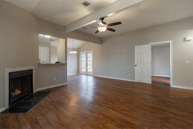 unfurnished living room with baseboards, visible vents, a tiled fireplace, lofted ceiling with beams, and wood finished floors