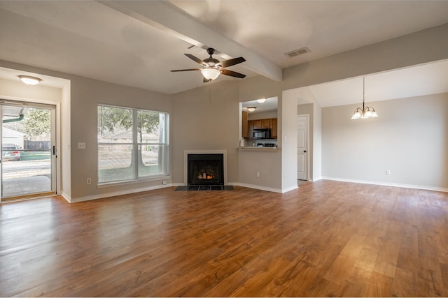 unfurnished living room featuring visible vents, a fireplace with flush hearth, wood finished floors, baseboards, and ceiling fan with notable chandelier