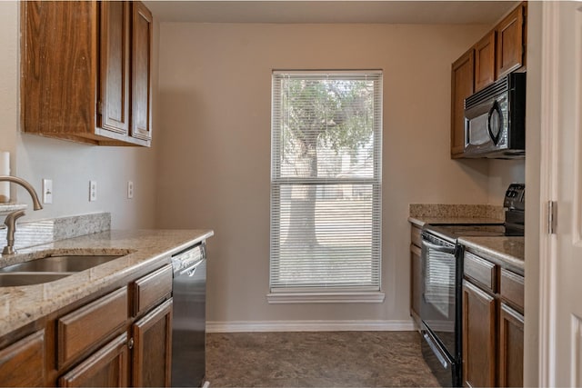 kitchen featuring baseboards, black appliances, a sink, and brown cabinets