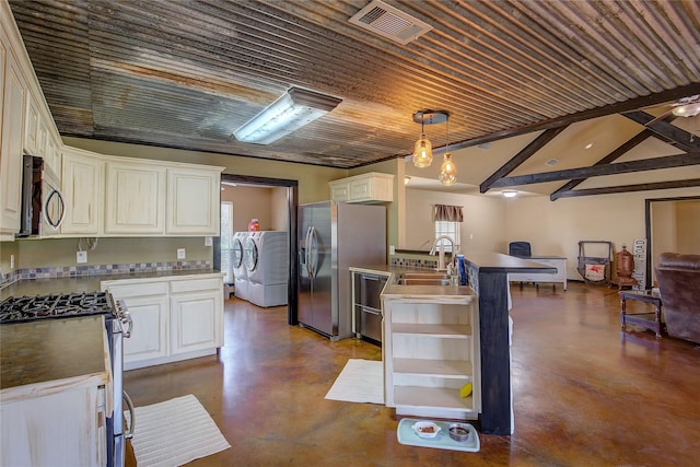 kitchen featuring appliances with stainless steel finishes, concrete floors, a sink, and washing machine and clothes dryer