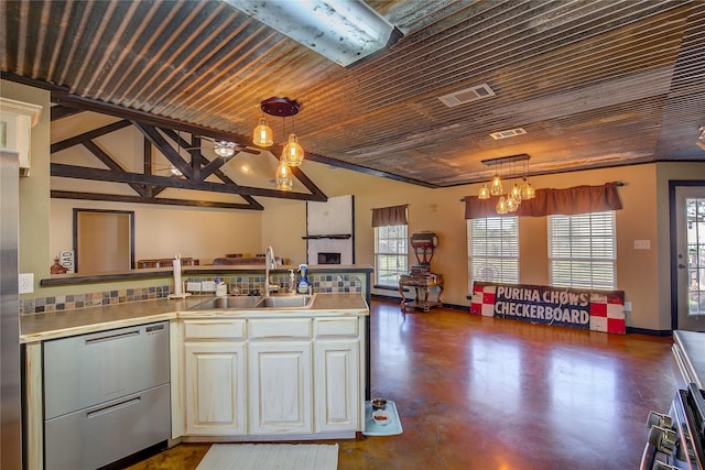 kitchen featuring a sink, visible vents, finished concrete flooring, vaulted ceiling, and pendant lighting