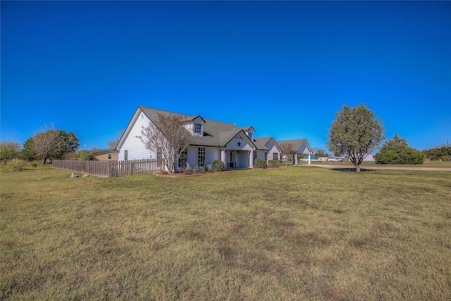 exterior space featuring fence and a front lawn