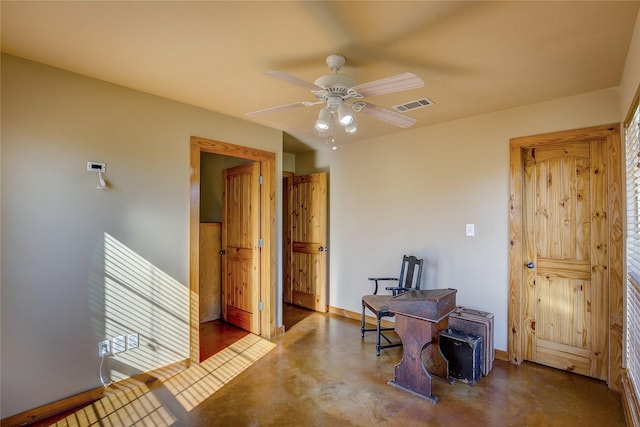 interior space with visible vents, concrete floors, baseboards, and ceiling fan