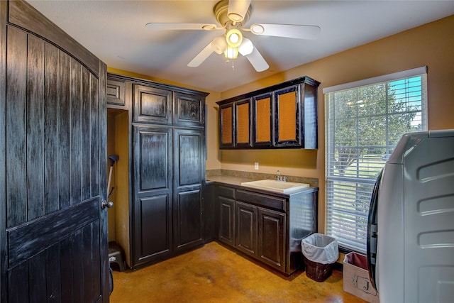 kitchen with a wealth of natural light, a ceiling fan, dark brown cabinets, and a sink