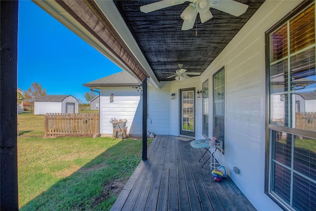 wooden terrace with covered porch, a lawn, fence, and a ceiling fan