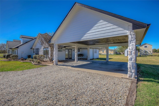 view of front of house featuring a carport, a front yard, and gravel driveway