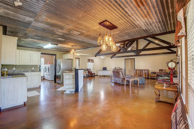 interior space featuring visible vents, finished concrete floors, a chandelier, and washer / dryer