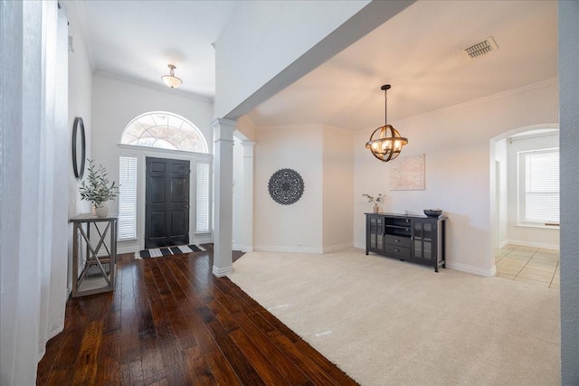 foyer entrance with ornamental molding, visible vents, decorative columns, and baseboards