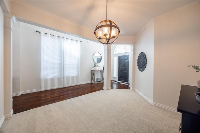 interior space featuring ornamental molding, a chandelier, baseboards, and ornate columns