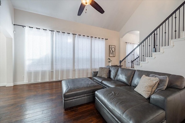 living room featuring arched walkways, a ceiling fan, lofted ceiling, stairway, and hardwood / wood-style floors