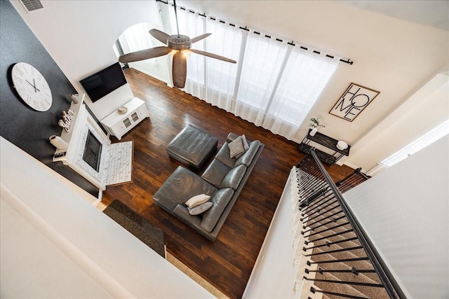 unfurnished living room with a ceiling fan, visible vents, and wood finished floors