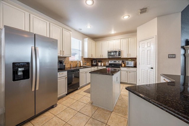 kitchen featuring visible vents, decorative backsplash, appliances with stainless steel finishes, light tile patterned flooring, and a sink