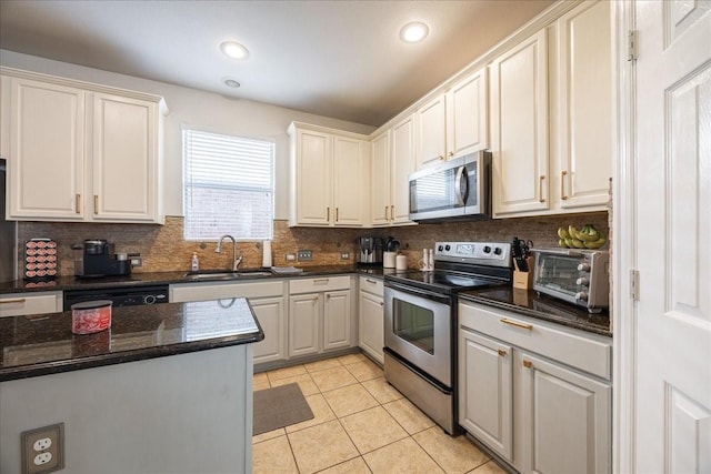 kitchen with light tile patterned floors, tasteful backsplash, a toaster, stainless steel appliances, and a sink