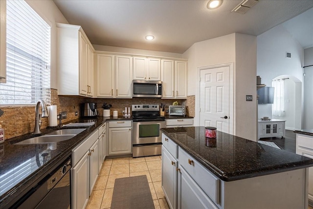 kitchen with light tile patterned flooring, a sink, visible vents, appliances with stainless steel finishes, and tasteful backsplash