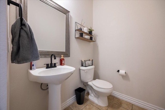 bathroom with toilet, tile patterned flooring, and baseboards