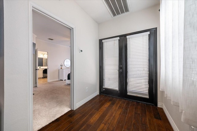 interior space with dark wood-style floors, visible vents, and baseboards