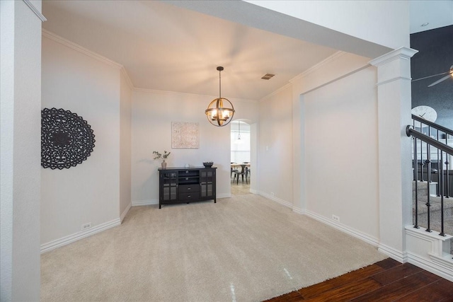 unfurnished dining area with carpet floors, visible vents, ornamental molding, a chandelier, and baseboards