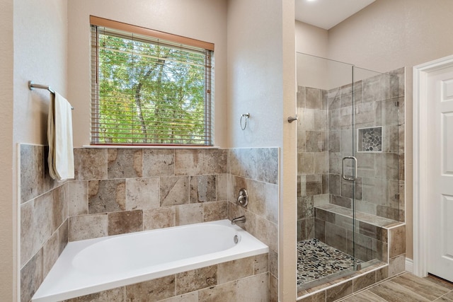 full bathroom featuring a healthy amount of sunlight, a stall shower, and a bath