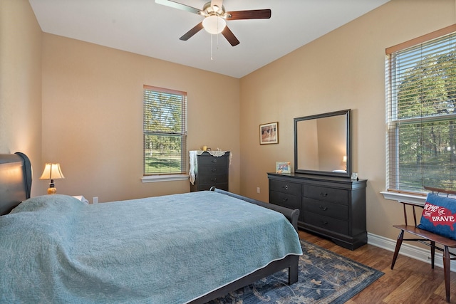 bedroom with ceiling fan, baseboards, and wood finished floors