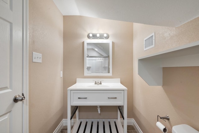 bathroom with visible vents, toilet, vanity, and baseboards