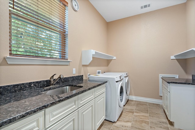 laundry room with washing machine and clothes dryer, cabinet space, visible vents, a sink, and baseboards