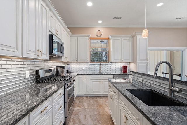 kitchen with appliances with stainless steel finishes, a sink, and visible vents