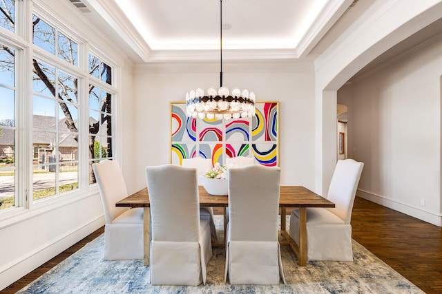 1717 Buckingham Dr, Keller, TX 76262 - dining space featuring a chandelier, wood finished floors, arched walkways, ornamental molding, and a raised ceiling