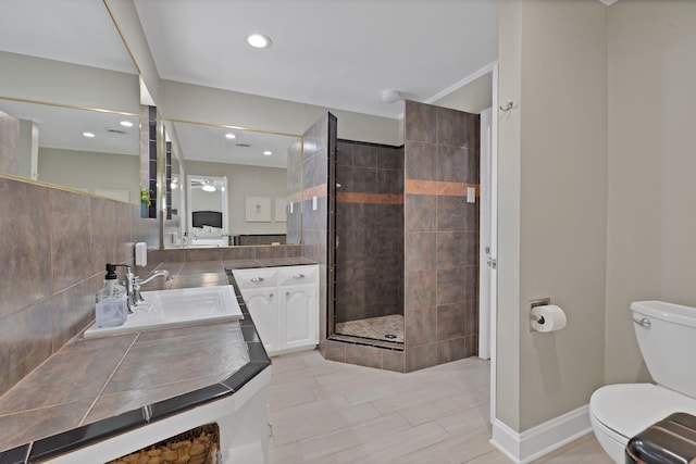 bathroom with baseboards, decorative backsplash, toilet, vanity, and a shower stall