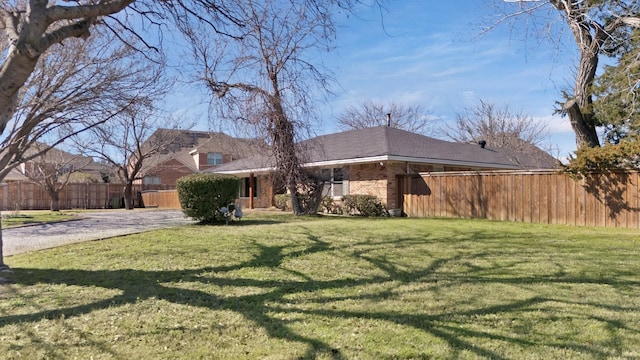 exterior space with fence, a front lawn, and brick siding