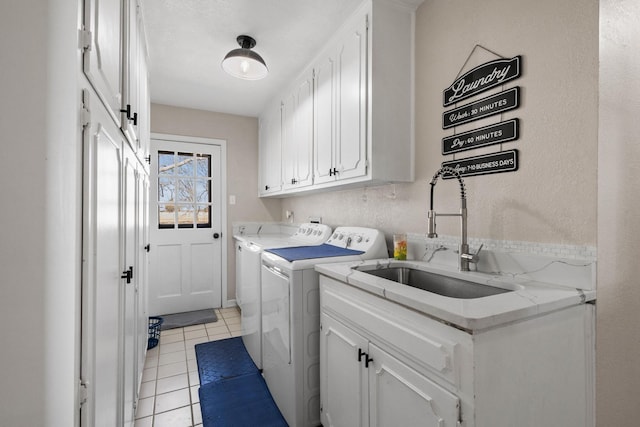 clothes washing area featuring light tile patterned floors, separate washer and dryer, a sink, and cabinet space